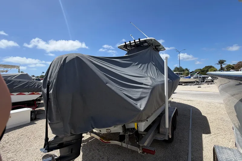 Slide: The Image of Covered 2023 Sea Hunt Ultra 234 boat on trailer under clear blue sky. - 8