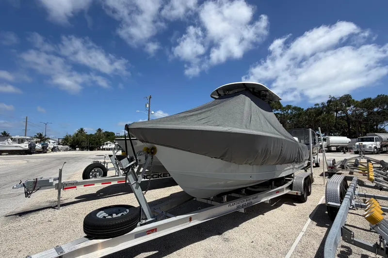 Slide: The Image of 2023 Sea Hunt Ultra 234 boat covered on trailer under blue sky. - 9