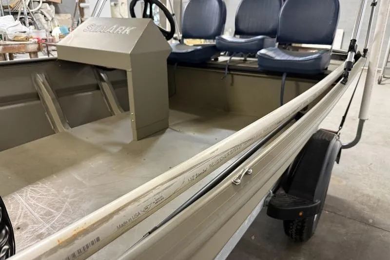 Slide: The Image of 2026 SeaArk 1648 MV Special boat interior with blue seats and steering console. - 4