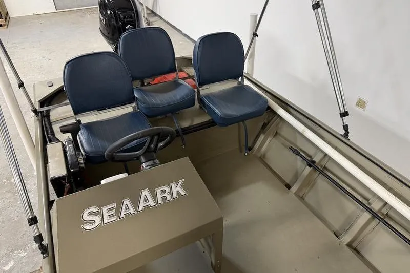 Slide: The Image of 2026 SeaArk 1648 MV Special boat interior with three blue seats and steering console. - 5