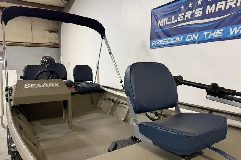Slide: The Image of 2026 SeaArk 1648 MV Special boat interior with blue seats at Miller's Marine showroom. - 6