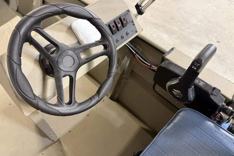 Slide: The Image of Steering console of 2026 SeaArk 1648 MV Special boat, featuring controls and switches. - 8