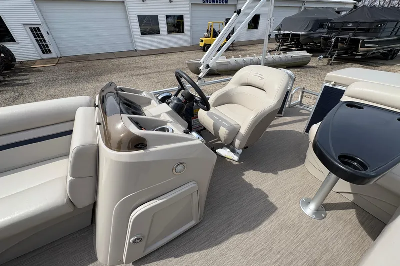 Slide: The Image of 2018 Bennington 188 SL boat interior with beige seating and steering console. - 15