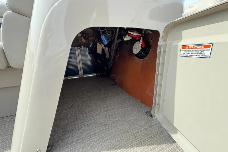 Slide: The Image of Storage compartment of a 2018 Bennington 188 SL boat, showing wiring and warning label. - 16