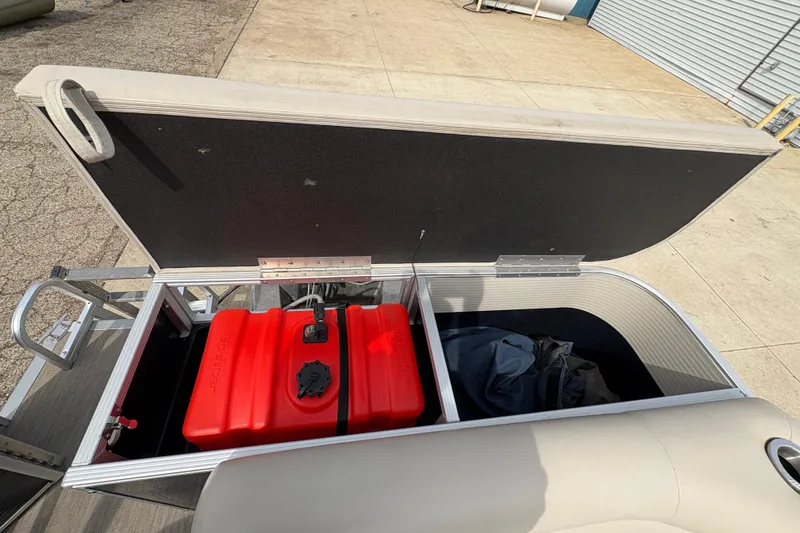 Slide: The Image of Open storage compartment of 2018 Bennington 188 SL boat with red fuel tank. - 19
