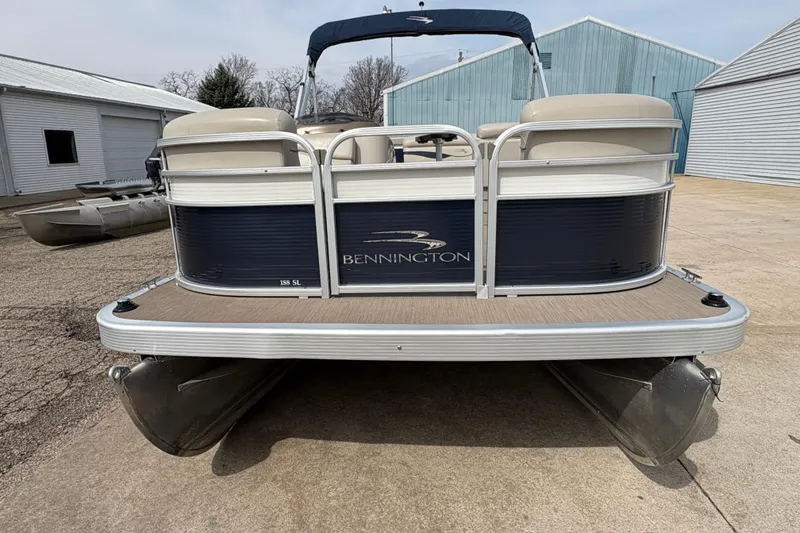 Slide: The Image of 2018 Bennington 188 SL pontoon boat parked on concrete near blue buildings. - 6