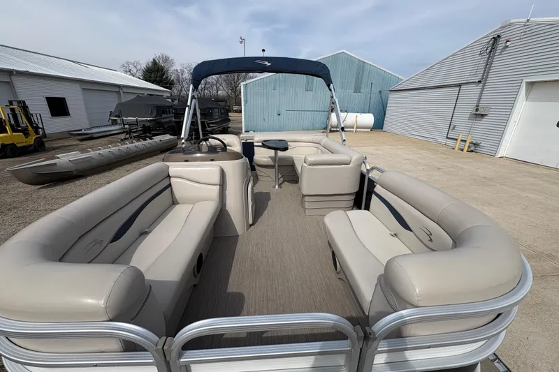 Slide: The Image of 2018 Bennington 188 SL pontoon boat with beige seating, docked outdoors. - 7