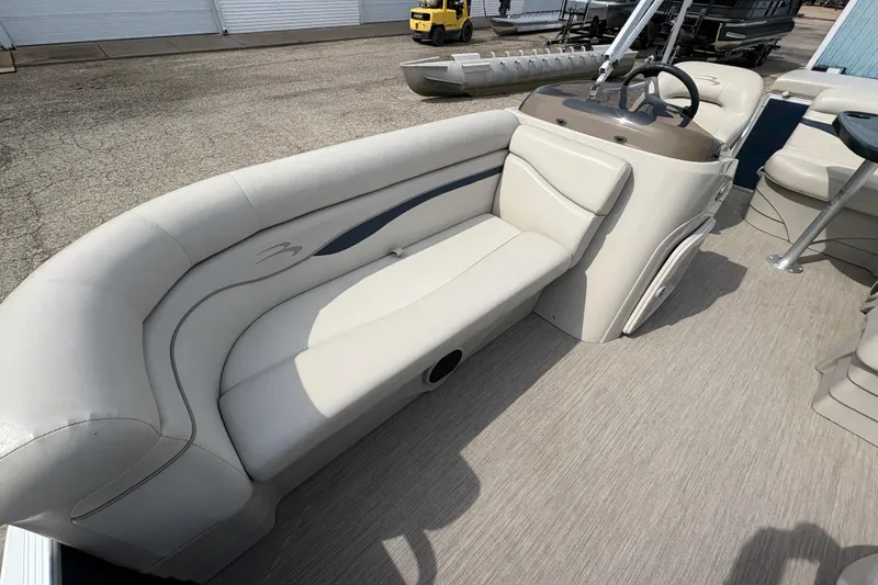 Slide: The Image of 2018 Bennington 188 SL pontoon boat interior with beige seating and steering console. - 8