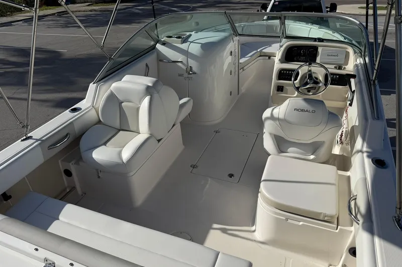 Slide: The Image of 2016 Robalo R227 Dual Console boat interior with white seating and steering console. - 10