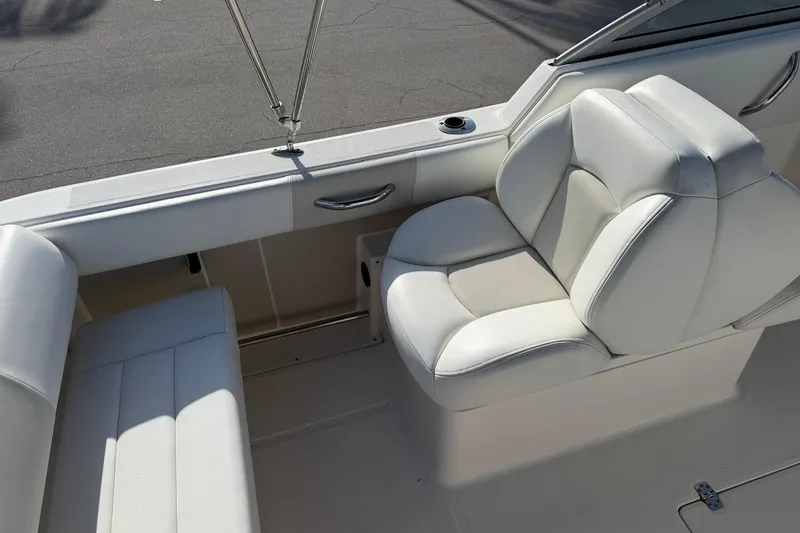 Slide: The Image of 2016 Robalo R227 Dual Console boat interior with white seating and cup holder. - 13