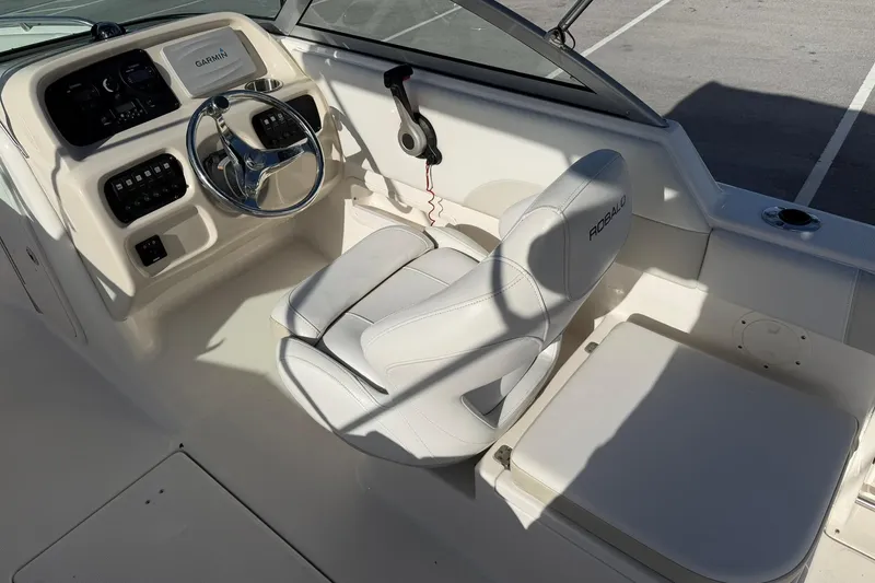 Slide: The Image of 2016 Robalo R227 Dual Console boat cockpit with steering wheel and Garmin display. - 16