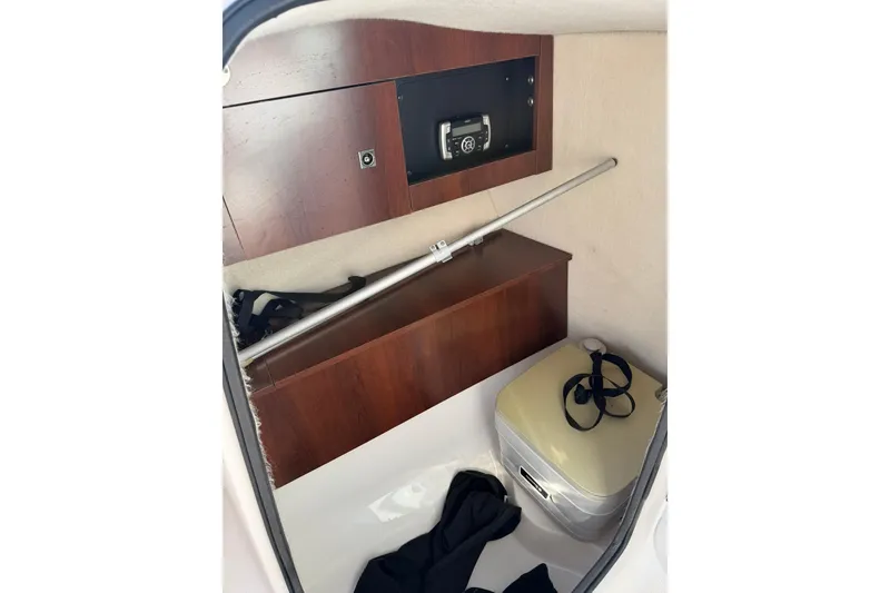 Slide: The Image of Interior of 2016 Robalo R227 Dual Console boat with storage and portable toilet. - 18