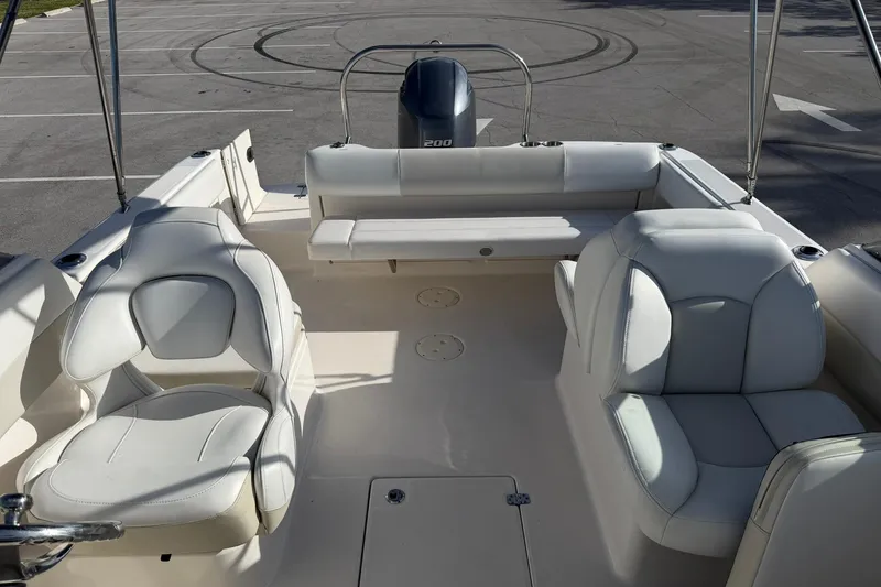 Slide: The Image of 2016 Robalo R227 Dual Console boat interior with white seating and outboard motor. - 22