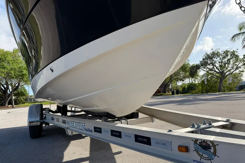 Slide: The Image of 2016 Robalo R227 Dual Console boat on a Venture trailer, parked outdoors. - 8