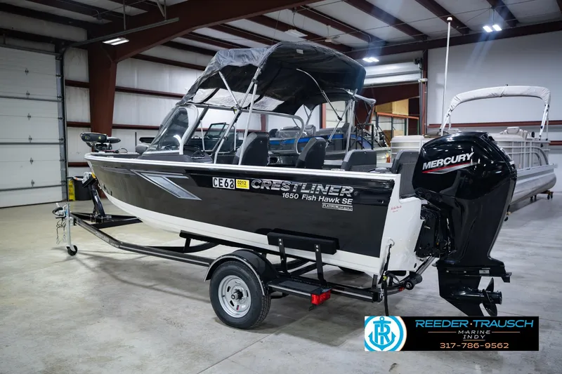 Slide: The Image of 2014 Crestliner 1650 Fish Hawk SE boat with Mercury engine in indoor showroom. - 10