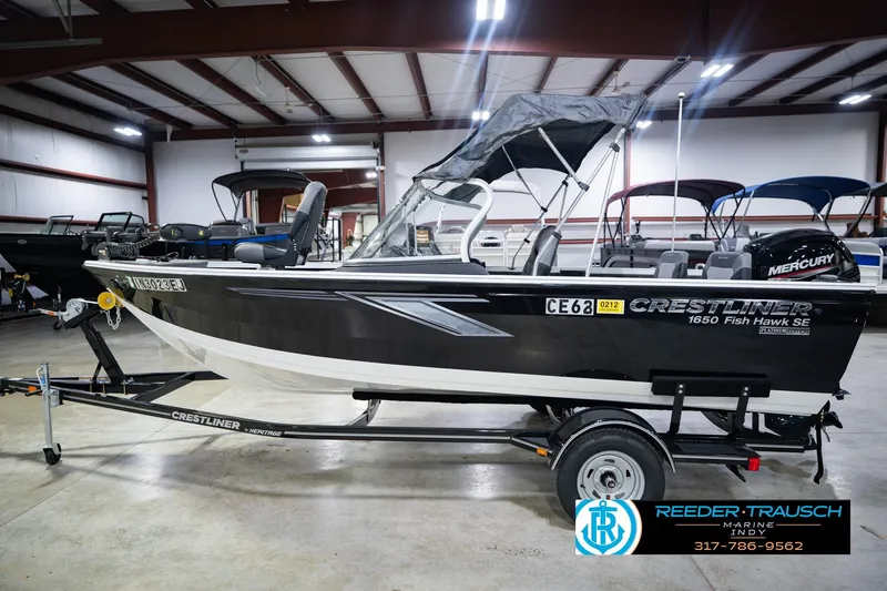 Slide: The Image of 2014 Crestliner 1650 Fish Hawk SE boat on trailer in indoor showroom. - 11