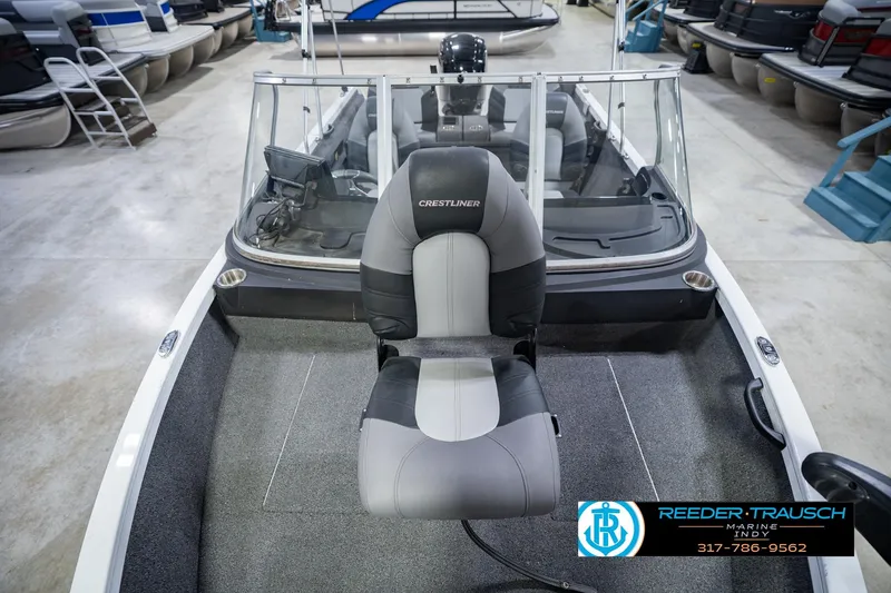Slide: The Image of 2014 Crestliner 1650 Fish Hawk SE boat interior with seating and windshield in showroom. - 19