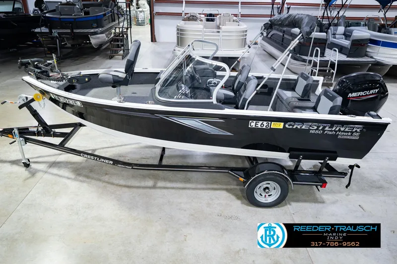 The Image of 2014 Crestliner 1650 Fish Hawk SE boat on trailer in showroom. - 2
