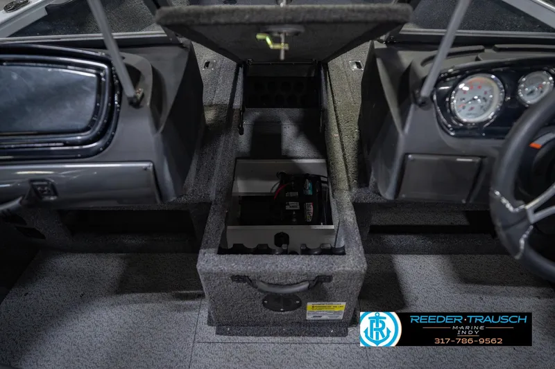 Slide: The Image of 2014 Crestliner 1650 Fish Hawk SE interior with open storage compartment and dashboard view. - 29