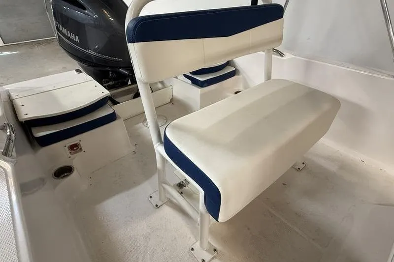 Slide: The Image of 2025 Robalo R160 Center Console boat interior with white and blue seating, Yamaha engine visible. - 6