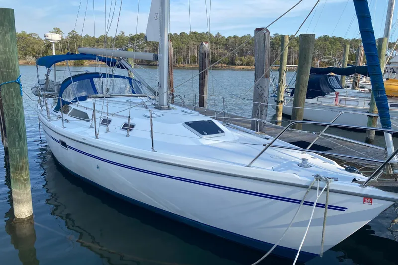 The Image of 1998 Catalina 36 MkII sailboat docked at a marina, surrounded by calm water. - 0