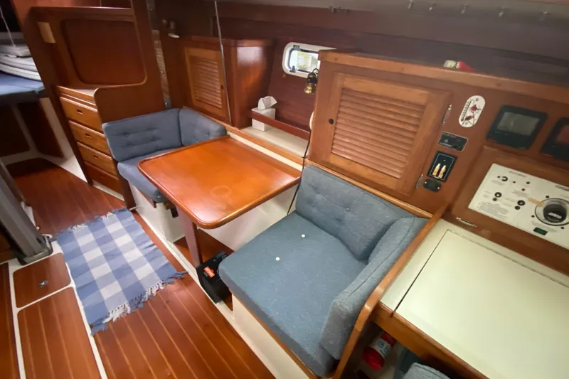 Slide: The Image of Cozy interior of 1998 Catalina 36 MkII sailboat with wooden table and blue seating. - 11