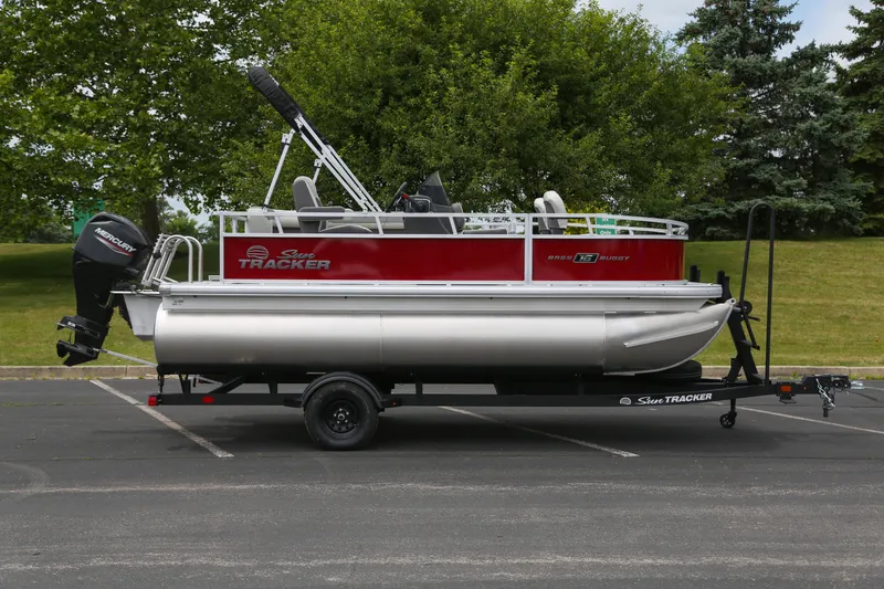 Slide: The Image of 2026 Sun Tracker Bass Buggy 16 XL Select pontoon boat on trailer, parked outdoors. - 77