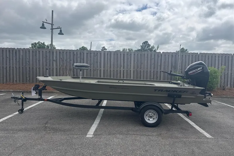 The Image of 2026 Tracker Grizzly 1654 T Sportsman boat on trailer, parked outdoors. - 0