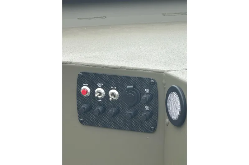 Slide: The Image of Control panel of 2026 Tracker Grizzly 1654 T Sportsman boat with switches and speaker. - 7