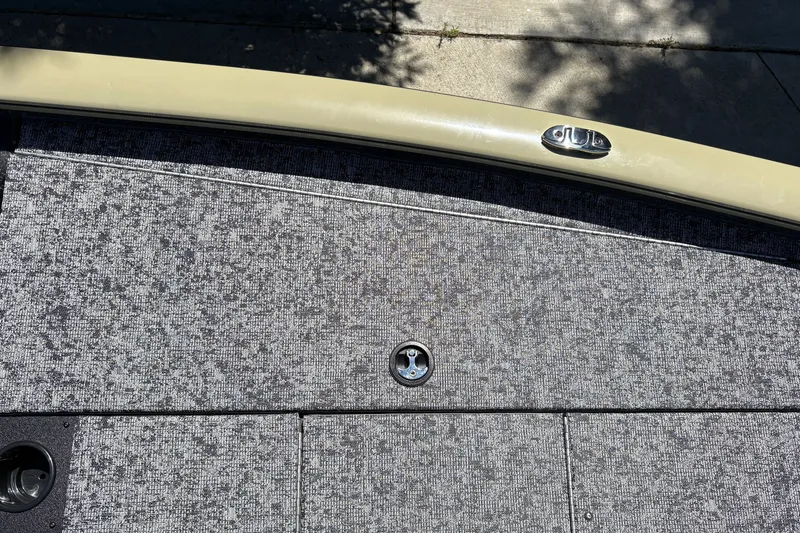 Slide: The Image of 2026 Tracker Pro Team 195 boat deck with textured gray carpeting and metal fixtures. - 40