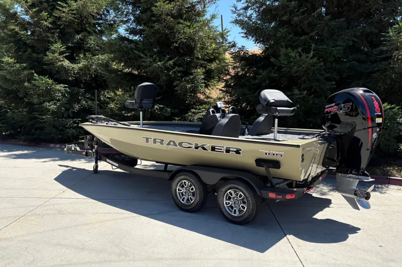 Slide: The Image of 2026 Tracker Pro Team 195 boat on trailer, parked outdoors near trees. - 5