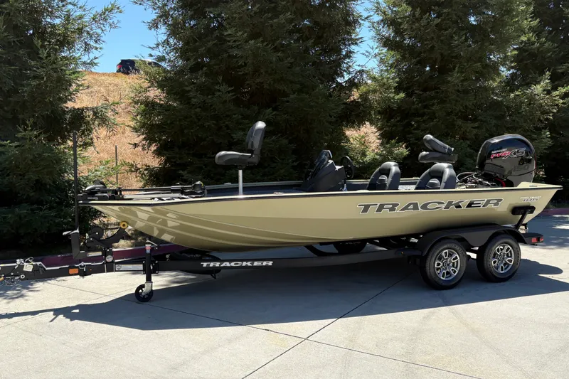 Slide: The Image of 2026 Tracker Pro Team 195 boat on trailer, parked outdoors near trees. - 7