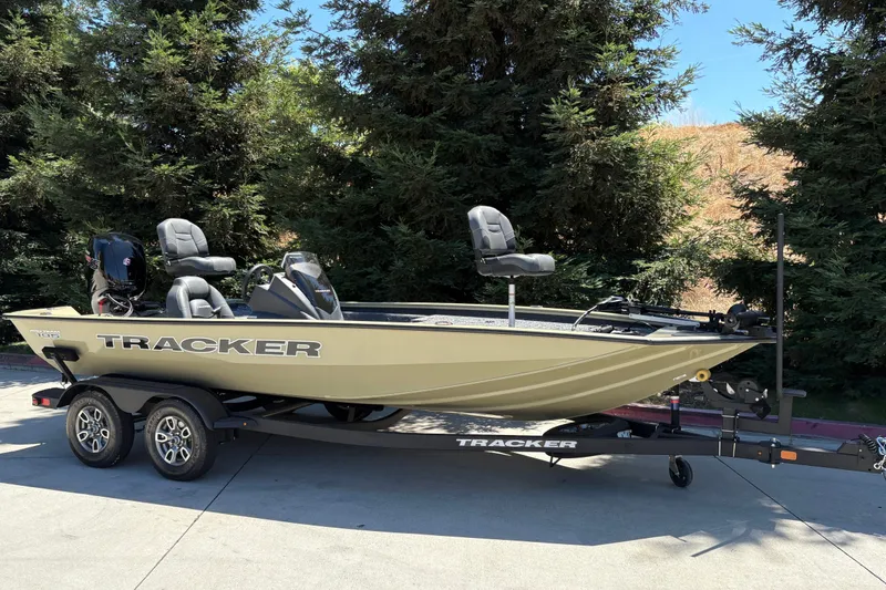 Slide: The Image of 2026 Tracker Pro Team 195 boat on trailer, parked outdoors near trees. - 3
