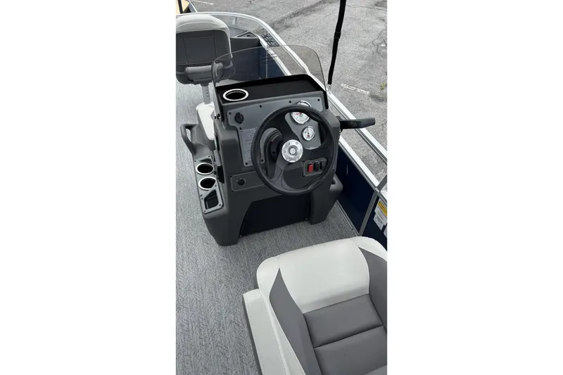 Slide: The Image of 2026 Sun Tracker Bass Buggy 18 DLX boat console with steering wheel and gauges. - 1