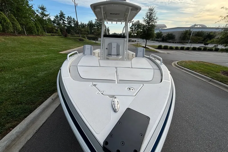 Slide: The Image of 2026 Ranger 2510 Bay boat parked on a road, surrounded by greenery and trees. - 6