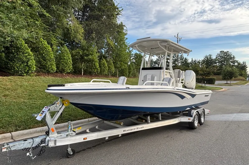 Slide: The Image of 2026 Ranger 2510 Bay boat on trailer, parked on a suburban street. - 2