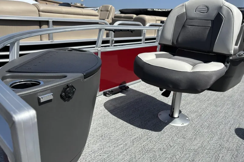 Slide: The Image of 2026 Sun Tracker Bass Buggy 18 DLX pontoon boat interior with seating and console. - 3
