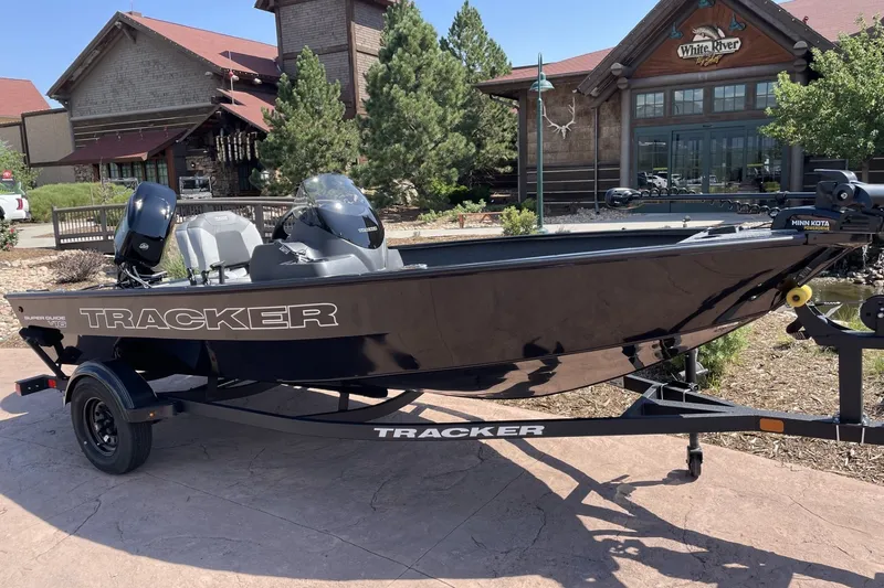 The Image of 2026 Tracker Pro 170 boat on trailer outside rustic building. - 0