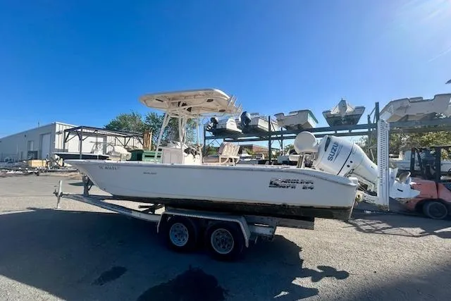 The Image of 2023 Carolina Skiff 24 Ultra Elite boat on trailer, parked outdoors under clear blue sky. - 0
