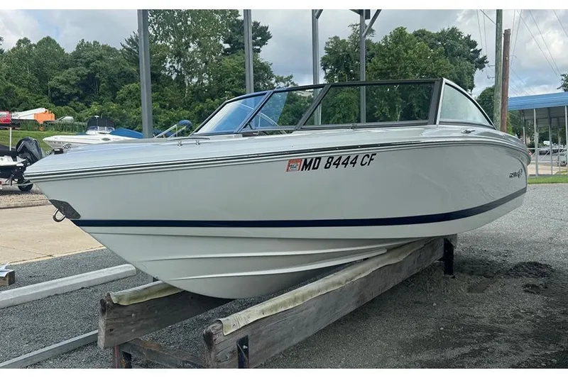 The Image of 2014 Cobalt 200 boat on trailer, parked outdoors with trees in background. - 0