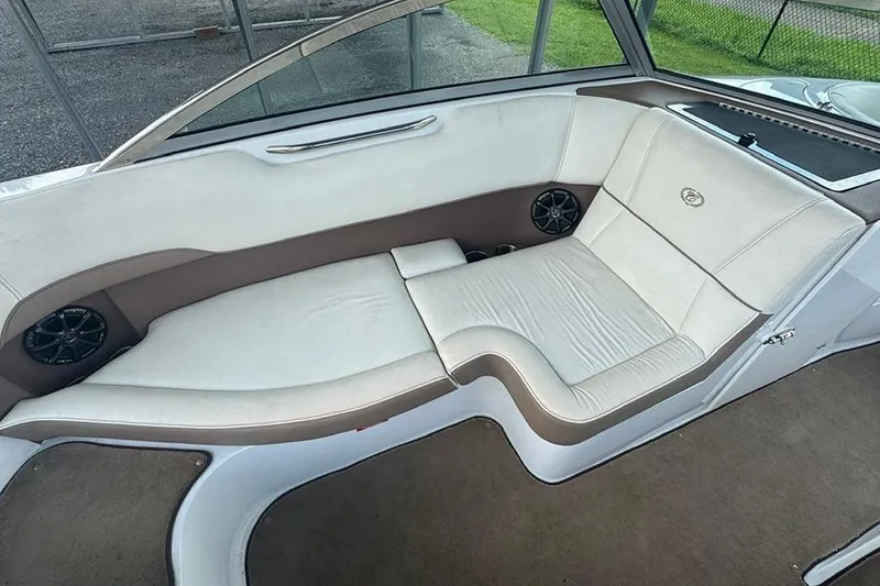 Slide: The Image of 2014 Cobalt 200 boat interior with beige seating and built-in speakers. - 11