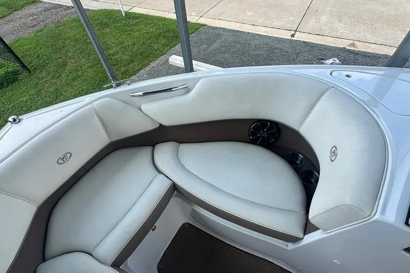 Slide: The Image of 2014 Cobalt 200 boat interior with white cushioned seating and cup holders. - 14