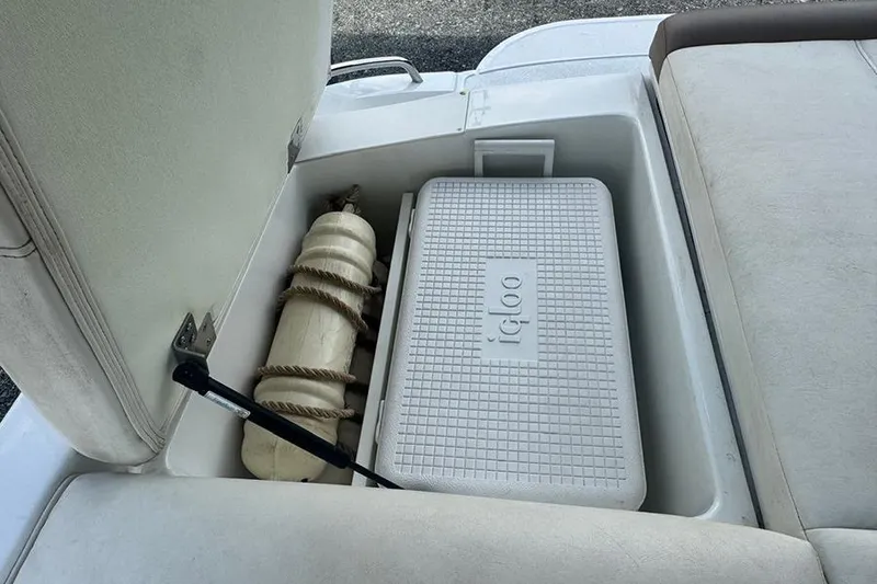 Slide: The Image of Storage compartment in a 2014 Cobalt 200 boat with an Igloo cooler and fender. - 15