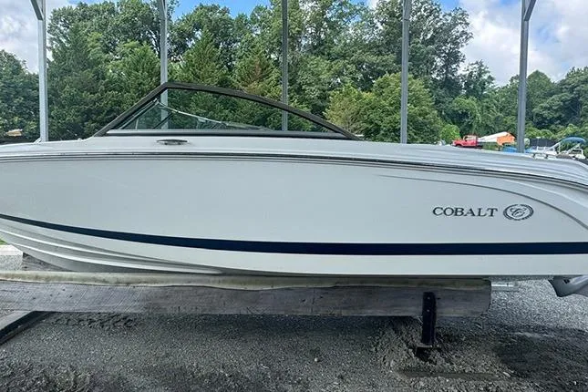 Slide: The Image of 2014 Cobalt 200 boat on display, white exterior, parked outdoors. - 4
