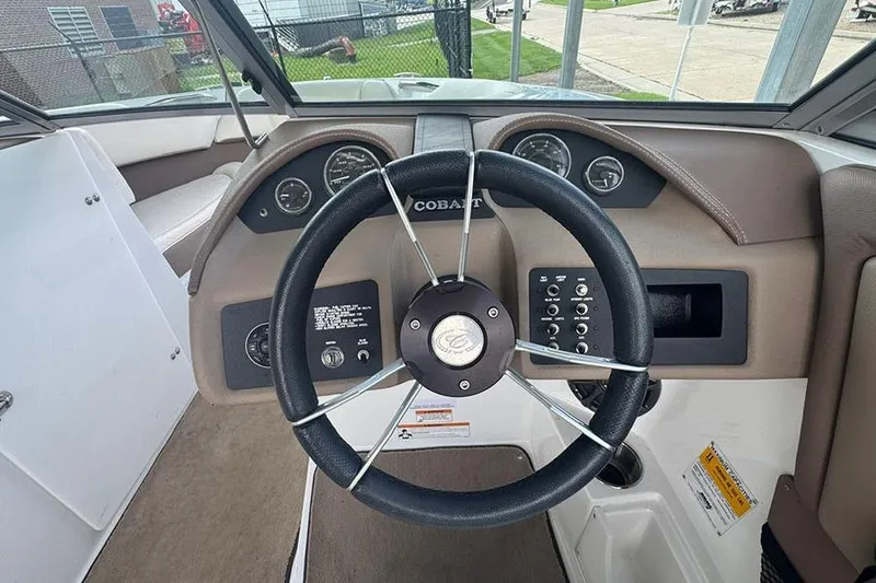 Slide: The Image of Steering wheel and dashboard of a 2014 Cobalt 200 boat, featuring gauges and controls. - 6