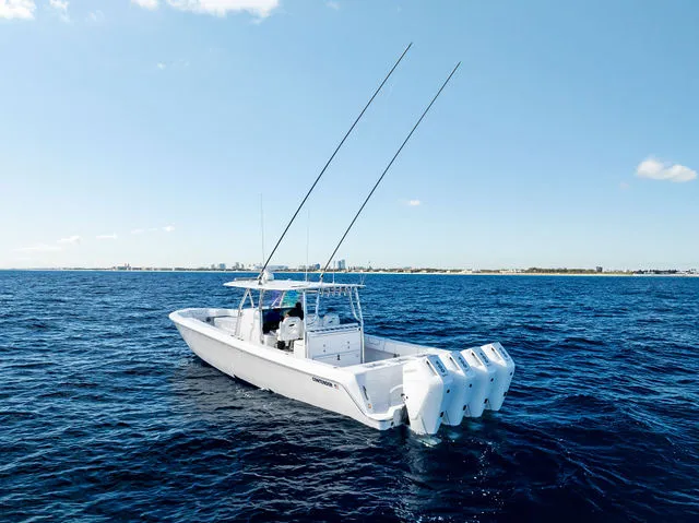 Slide: The Image of 2021 Contender 44 ST boat with red seating, docked under a clear blue sky. - 12