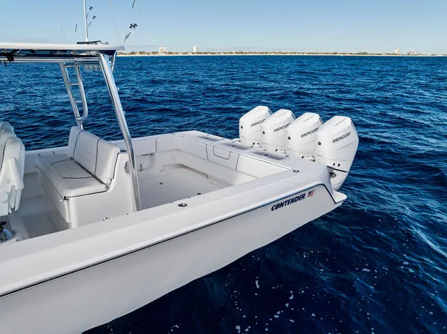 Slide: The Image of 2021 Contender 44 ST boat with open storage compartment, red seating, docked by waterfront. - 16