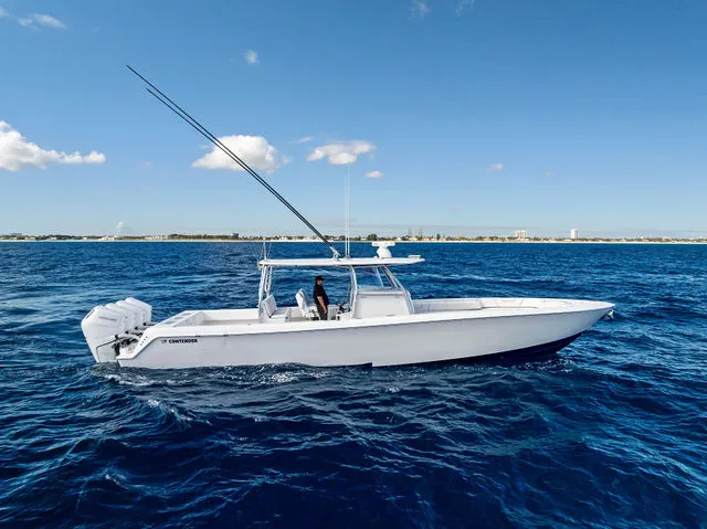 Slide: The Image of 2021 Contender 44 ST boat docked, featuring red seating and dual motors. - 18