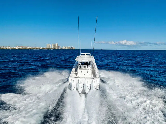 Slide: The Image of Four powerful outboard motors on a 2021 Contender 44 ST boat docked at a marina. - 25