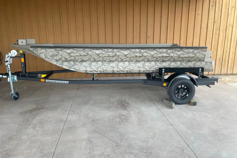 The Image of 2026 Reaper Boats 653 Timber Reaper on trailer, camouflage design, parked on concrete. - 1